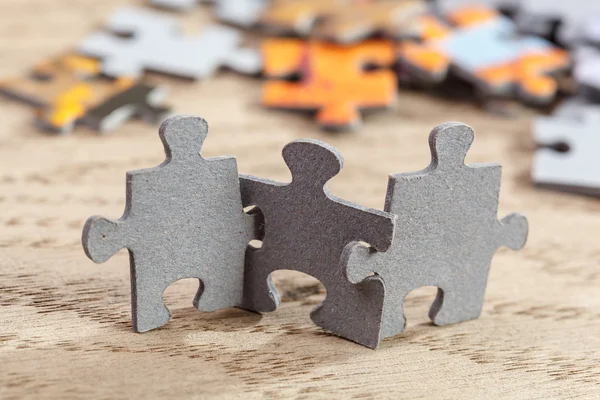 Drie stukken van de puzzel op tafel — Stockfoto