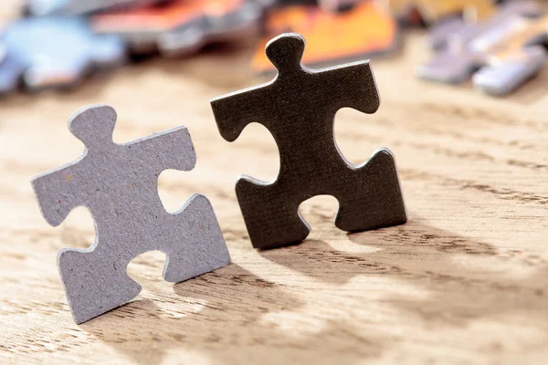 Siyah ve gri Jigsaw Puzzle parçaları masada — Stok fotoğraf