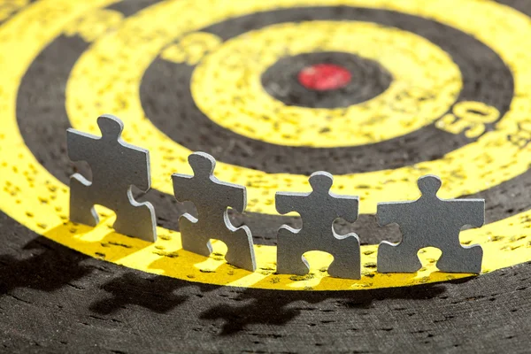 Four Jigsaw Puzzle Pieces on Old Yellow Target — Stock Photo, Image