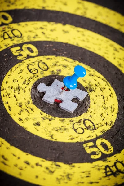 Blaue Nadel steckt in alter gelber Zielscheibe — Stockfoto