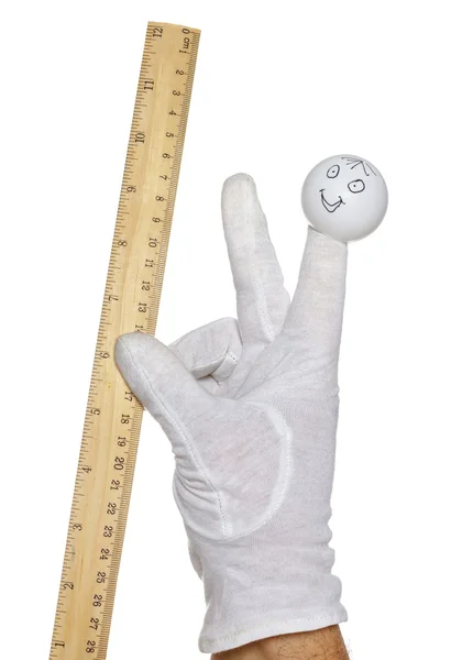 Finger puppet holding wooden rule — Stock Photo, Image