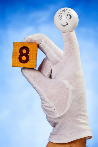 Número ocho en el cubo de madera sostener con el dedo títere — Foto de Stock