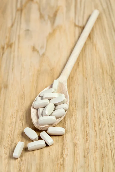 Food supplement on wooden spoon — Stock Photo, Image