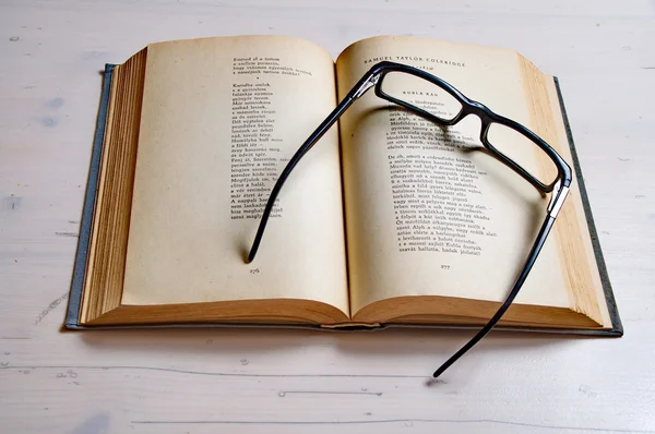 Reading glass on an old book — Stock Photo, Image