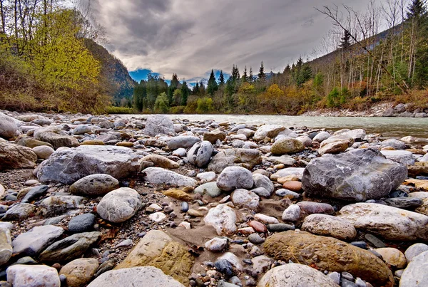 Rocas en el río que fluye en las montañas — Foto de Stock