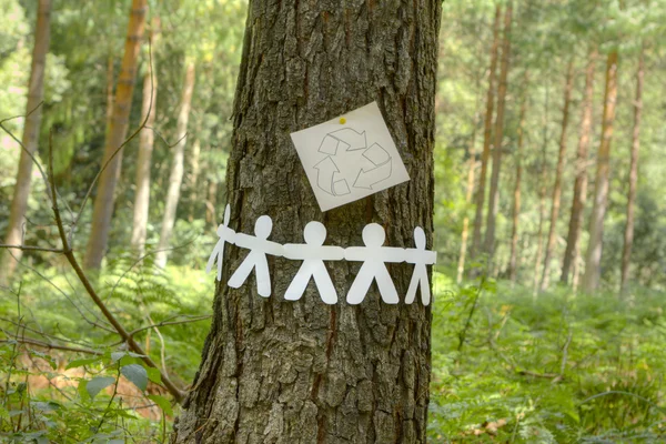 Утилизационный знак с бумажными людьми на дереве — стоковое фото
