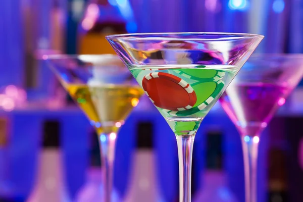 Casino chip in cocktail glasses with bar on back — Stock Photo, Image