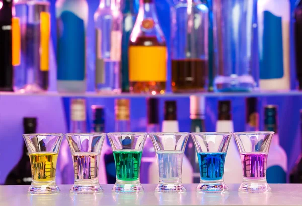 Big row of shots glasses with color drinks — Stock Photo, Image