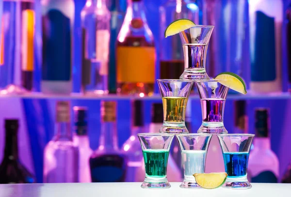 Pyramid of shot glasses with drinks and lime — Stock Photo, Image