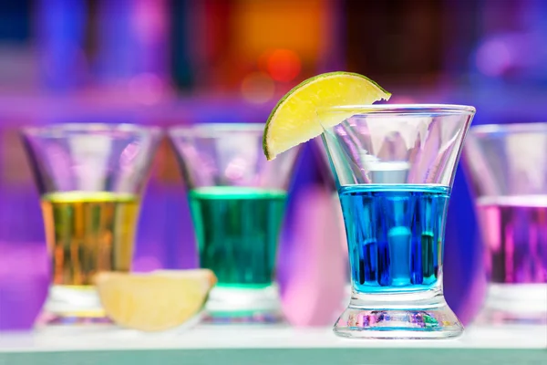 Enkele glazen met kleur drankjes en kalk in staaf — Stockfoto