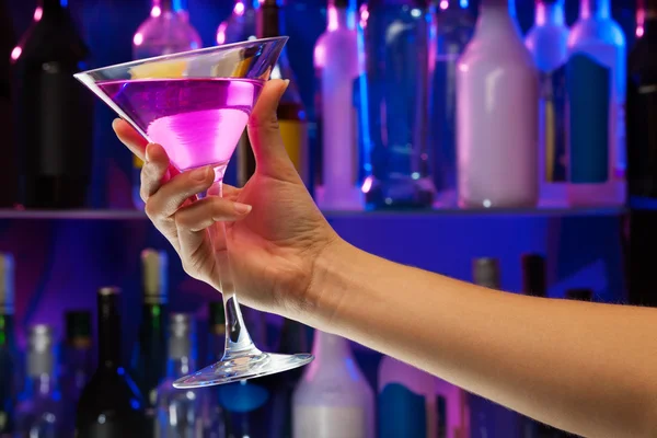 Copa de bebida alcohólica en mano de mujer dentro de la barra — Foto de Stock