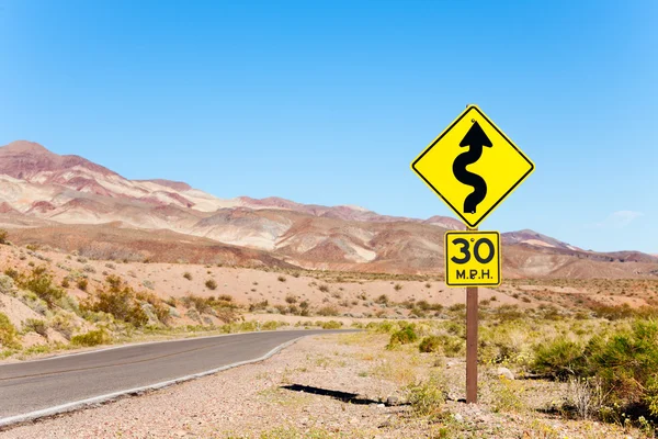 Дорога со стрелкой желтый знак в пустыне — стоковое фото
