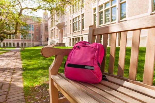 Üniversite bankta döşeme sırt çantası — Stok fotoğraf
