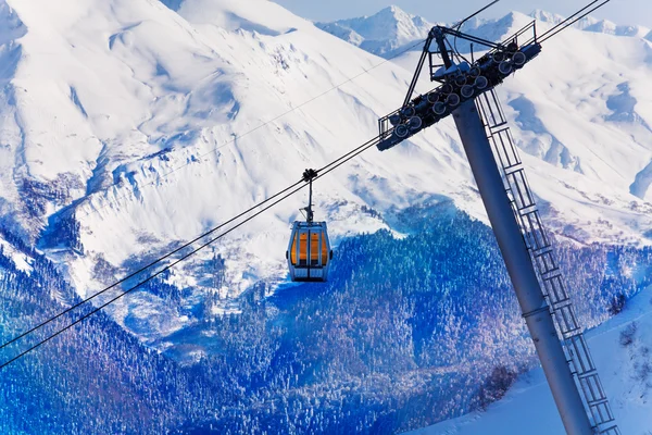Lonely cable car cabin over snow peaks — Stock Photo, Image