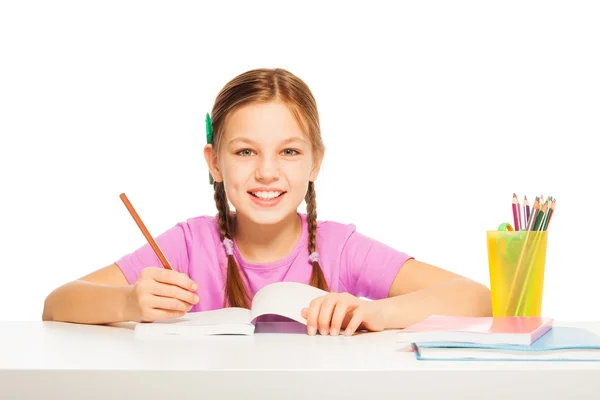 Schoolmeisje haar huiswerk aan de balie — Stockfoto