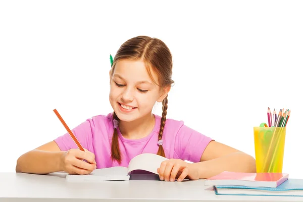Девочка в розовой футболке учится в школе — стоковое фото