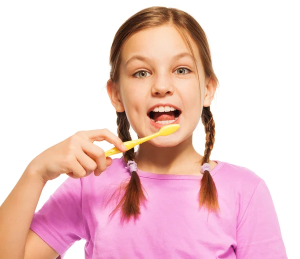 La chica divertida cepilla los dientes con cepillo amarillo — Foto de Stock
