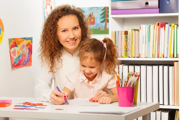 Leraar helpt haar leerling te schrijven — Stockfoto