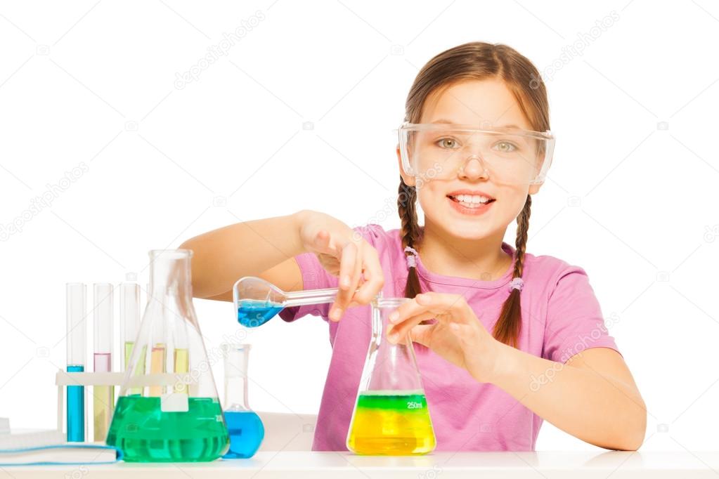 Young schoolgirl mixing blue and yellow reactants
