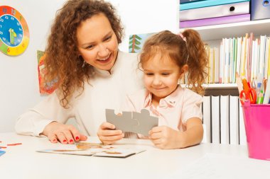 Öğretmen ve puzzle parçaları tutan kız portre