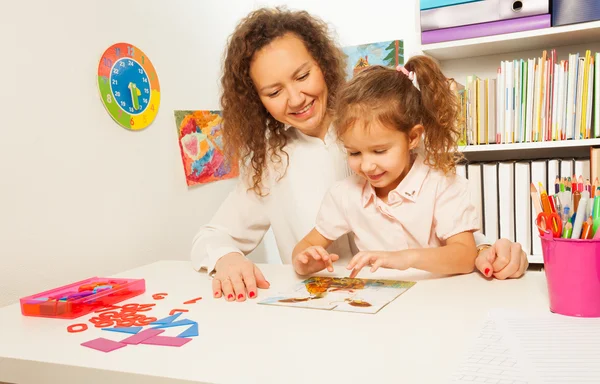 Schoolmeisje stuks samen een puzzel — Stockfoto