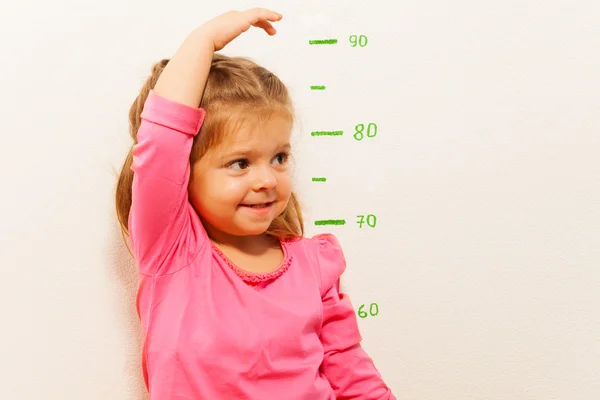 Height measurement by little girl at the wall — Stock Photo, Image