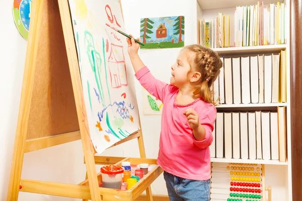 Child painting landscape picture on easel — Stock Photo, Image