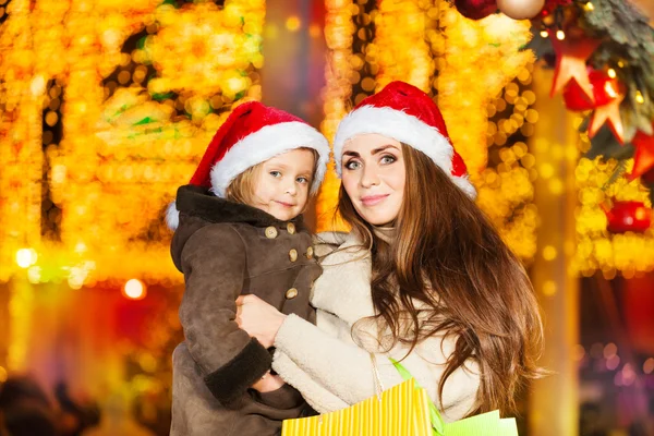 Anne ile kızı kırmızı Noel Baba'nın şapkalı — Stok fotoğraf