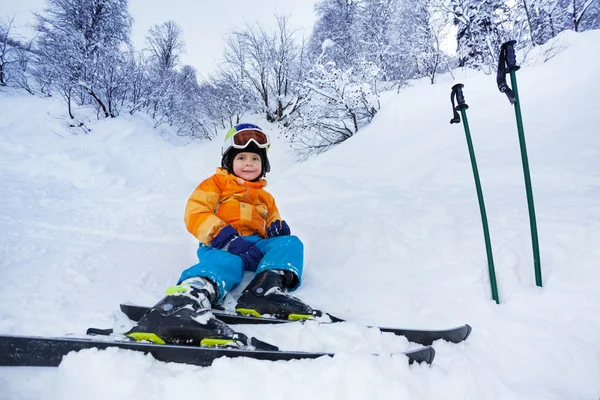 Liten skidåkare pojke resten i snö slitage skid outfit — Stockfoto