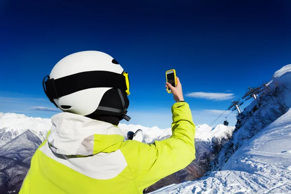 Skiër vrouw nemen van foto's van bergen — Stockfoto