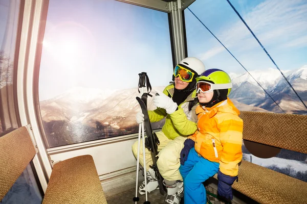 Mom talk to child sitting in ski lift cabin — Stock Photo, Image