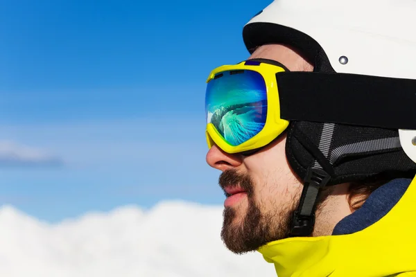 Homem em máscara de esqui sobre montanhas — Fotografia de Stock