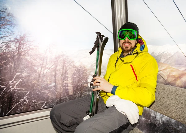 Hombre esquiador sentarse en telesilla cabina del teleférico —  Fotos de Stock