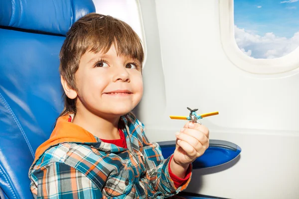 Little boy with toy plane fly in airplane — Stock Photo, Image