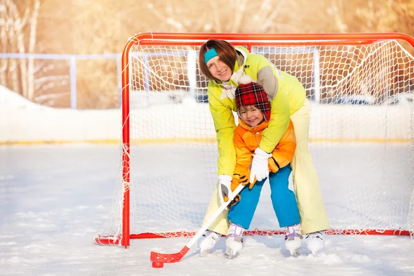 Mamá enseñar chico a jugar hockey sobre hielo —  Fotos de Stock