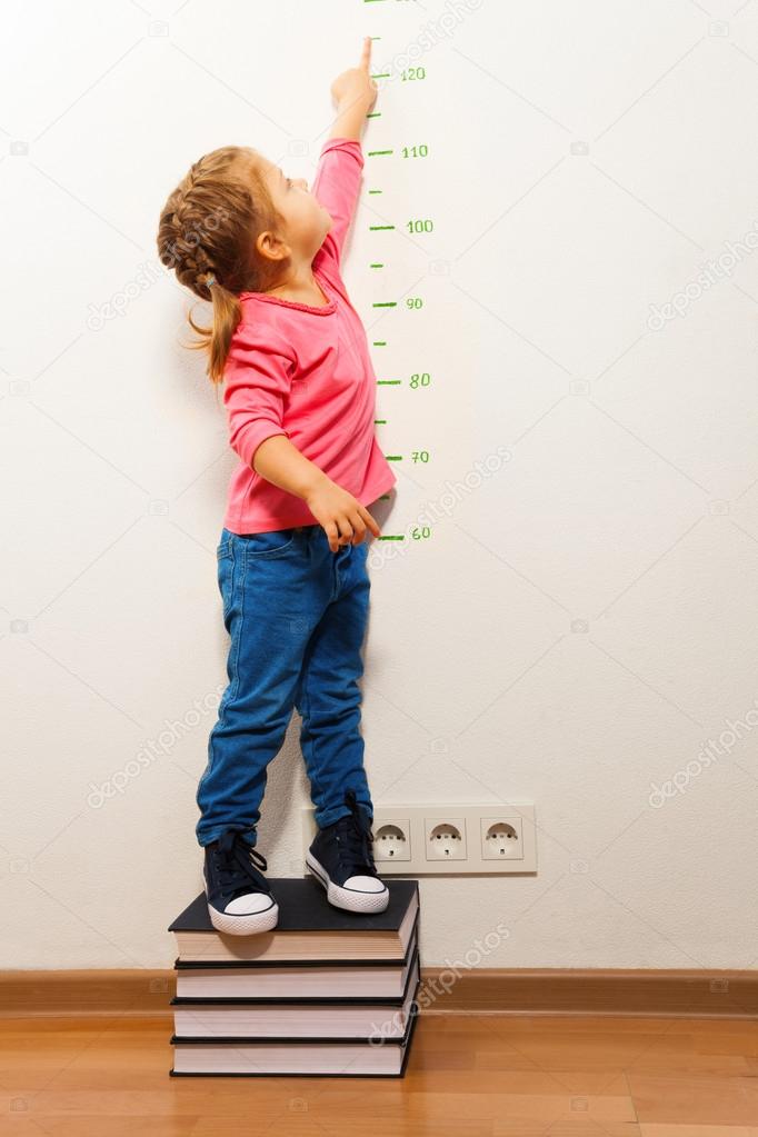 Girl checking height on growth chart