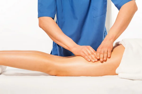 Masseur's hands kneading female hip — Stock Photo, Image