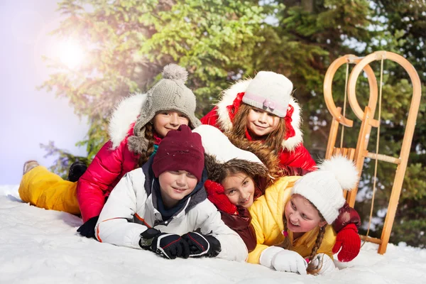 Felices amigos tirados en la nieve — Foto de Stock