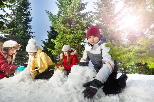 Dört çocuğu kardan adam yapma — Stok fotoğraf