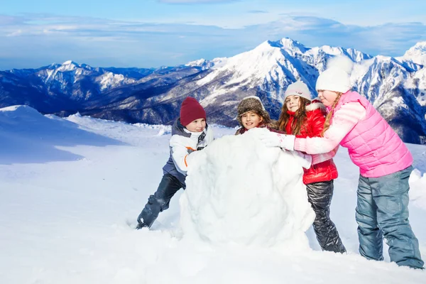 Friends rolling the snowball at winter — Stock Photo, Image