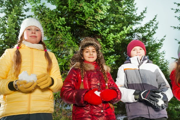 Boy and girls holding snowballs — Stock Photo, Image