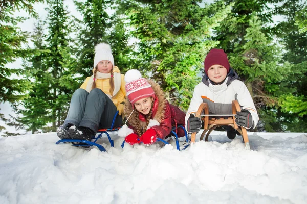 Αγοριών και κοριτσιών που κάθεται στο sledge τους — Φωτογραφία Αρχείου