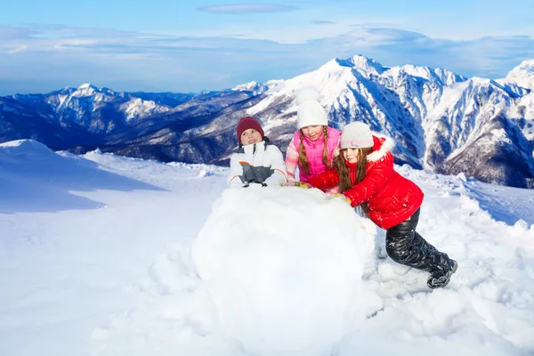 Crianças batendo a enorme bola de neve — Fotografia de Stock