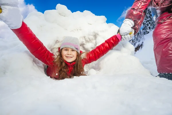 Amis tirent fille souriante de la neige — Photo