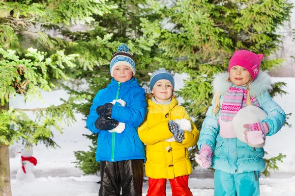 Хлопчики і дівчинка стоять зі сніговими кульками — стокове фото