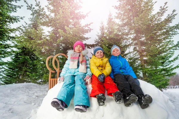 Niños se sienta en la pared de nieve —  Fotos de Stock