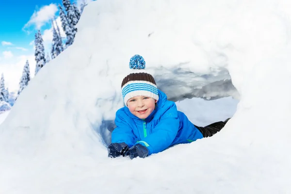 Feliz niño tendido en la nieve — Foto de Stock