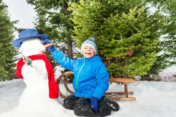 Jongetje maakt sneeuwpop — Stockfoto