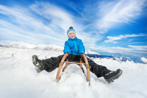 Snow mountains boy on sledge — Stock Photo, Image