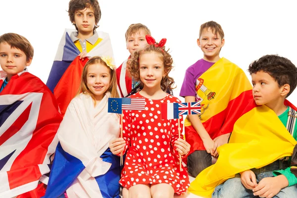 Enfants avec des drapeaux enveloppés dans différentes bannières — Photo